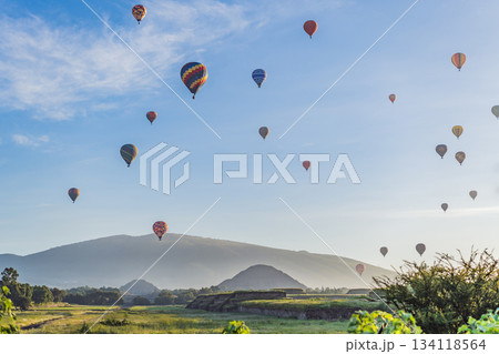 Colorful hot air balloons floating over Teotihuacan in Mexico, creating a breathtaking view of the ancient pyramids. Tourism, adventure, and cultural heritage concept 134118564