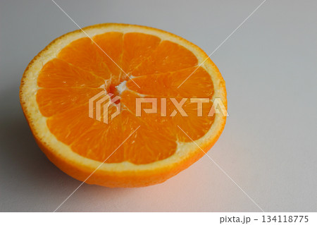 Ripe orange cut in half on a white surface at the side of the image. Stock photo for fruits backgrounds  134118775