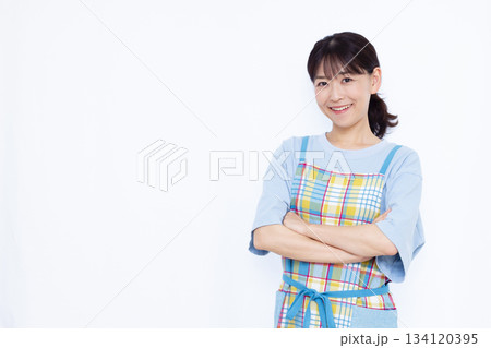 笑顔で腕組をして考えている主婦 134120395