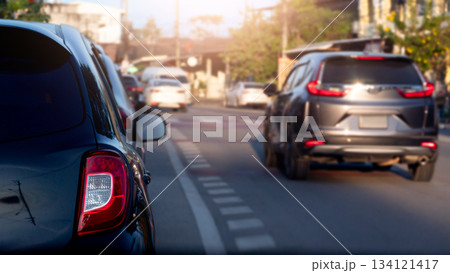 Rear side view luxury of black car. with other cars drive over to the side. Front side of car with sunlight and blurred of trees and town. at day time. 134121417