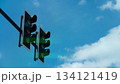 Look up below shows the sides of a double traffic light. Shows the green lights appearing on both sides. Signals a way through. Under blue sky and white clouds at day time. 134121419