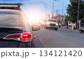 Rear side of black car with turn on brake light. Close up tail light of car with bright light of the brake lights. Blurred of other car on opposite road. With environment of city in the country. 134121420
