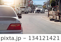 Rear side view of car in the traffic jam at day time. Many car drive behind the queue arranged in a curved line. With blurred of other car driving on the opposite lens on asphalt road at day. 134121421