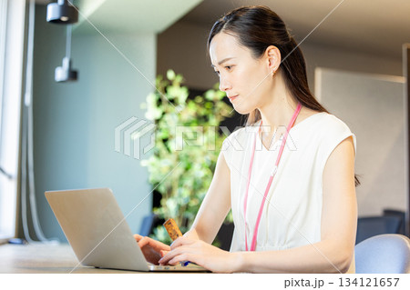 オフィスでプロテインバーを食べる女性 134121657