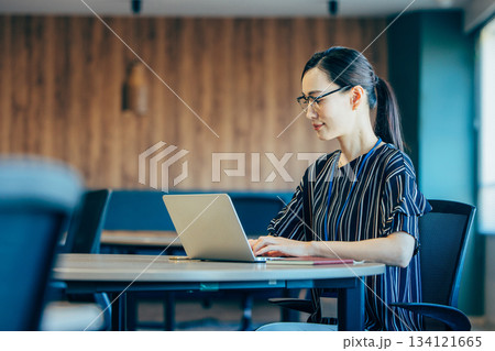 オフィスでパソコンを操作するミドルのビジネスウーマン 134121665