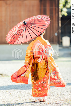 七五三で和傘をさして神社にお参りをする女の子 134124104