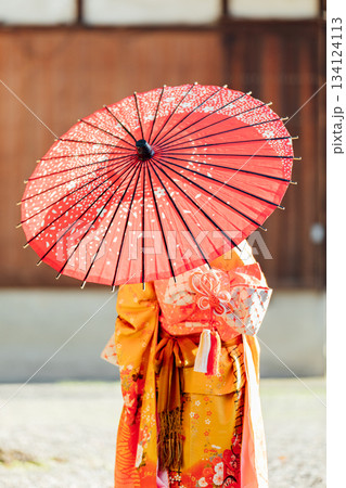 七五三で和傘をさして神社にお参りをする女の子 134124113