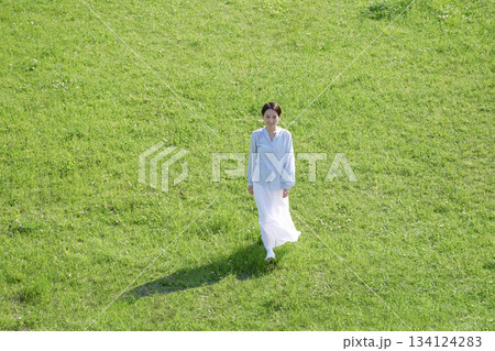 野原を散歩する女性 俯瞰撮影 野原を散歩する女性 俯瞰撮影 134124283
