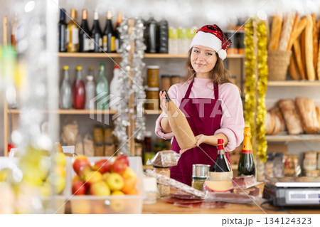 Young female seller with wine in grocery store 134124323
