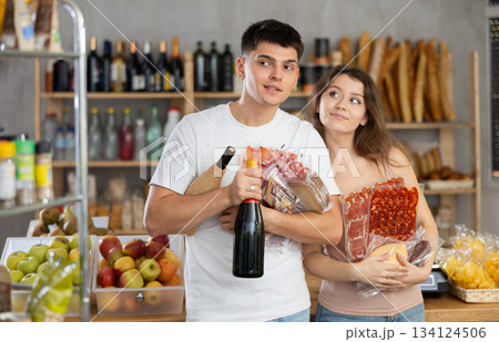 Couple man and woman choosing groceries in store 134124506