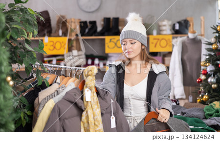 Young woman choosing coats and jackets at Christmas sale 134124624