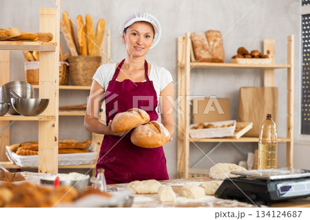 Woman baker holding bread Woman baker holding bread 134124687