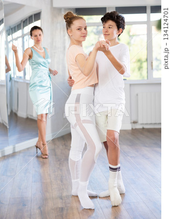 Passionate teen dancers, girl and boy practicing ballroom dancing in studio Passionate teen dancers, girl and boy practicing ballroom dancing in studio 134124701