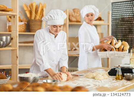 Women bakers making bread in a bakery Women bakers making bread in a bakery 134124773