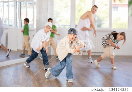 Preteen girl practicing hip hop choreography with peers and instructor Preteen girl practicing hip hop choreography with peers and instructor 134124825