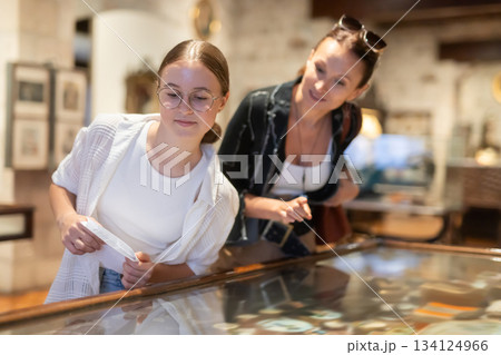 Woman and teenage girl looking at exhibit in museum display 134124966