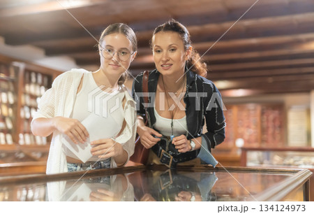 Woman and teenage girl looking at exhibit in museum display 134124973