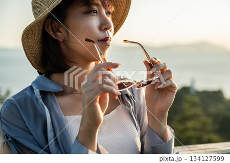 夕暮れ時の帽子女性 134127599