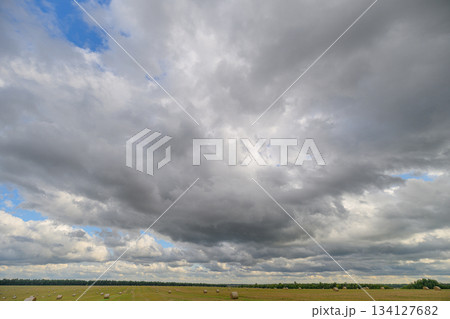 A Dramatic Cloud Formation Casts Shadows Over a Serene and Picturesque Landscape Scene 134127682