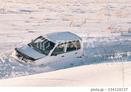 The car flew off the highway into the snow due to ice and drove into a ditch in a snowy field at high speed accident in winter. High quality photo The car flew off the highway into the snow due to ice and drove into a ditch in a snowy field at high speed accident in winter. High quality photo 134128137