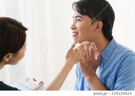 ひげ脱毛する若い男性をカウンセリングをするセラピスト 134128424