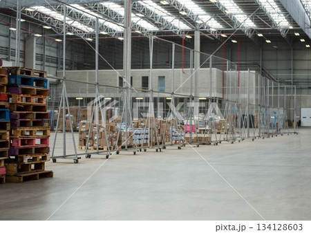 Flat design warehouse is showing mobile wire mesh fencing rolling on concrete floor under skylights 134128603