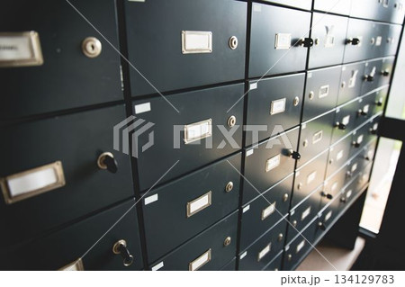 Depicting flat design dark-gray safe deposit box grid glowing under daylight window, keys dangling 134129783