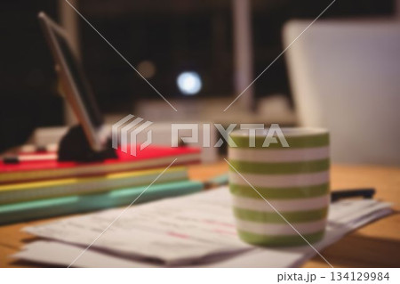 Coffee cup over papers by digital tablet Coffee cup over papers by digital tablet 134129984