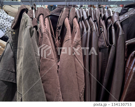 A clothing rack filled with various brown and earth-toned jackets displayed tightly together A clothing rack filled with various brown and earth-toned jackets displayed tightly together 134130753