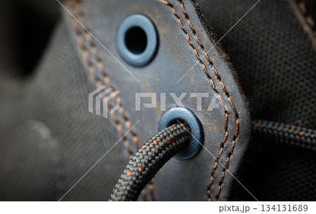 Detail of a shoelace threaded through an eyelet on fabric Detail of a shoelace threaded through an eyelet on fabric 134131689