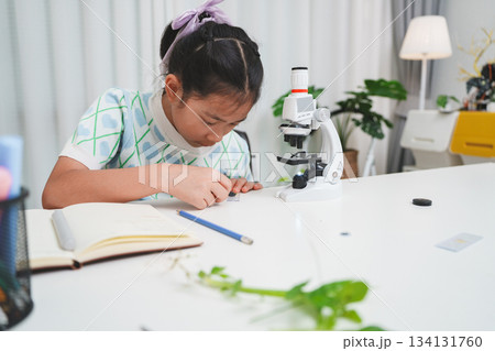 Elementary Girl Placing Slide on Microscope STEM Science Experiment Procedure 134131760