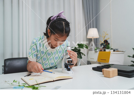 Elementary School Girl Taking Notes Science Experiment Microscope STEM Research Elementary School Girl Taking Notes Science Experiment Microscope STEM Research 134131804