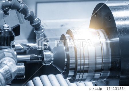 Close up scene multi-tasking CNC lathe machine swiss type hole drilling process the brass coupling parts in the light blue scene. Close up scene multi-tasking CNC lathe machine swiss type hole drilling process the brass coupling parts in the light blue scene. 134131884