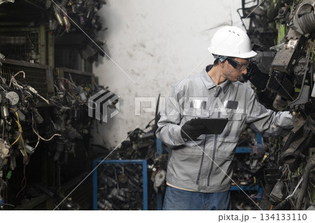 Technician worker working and checking in garage scrap yard car workshop warehouse. Technician worker working and checking in garage scrap yard car workshop warehouse. 134133110