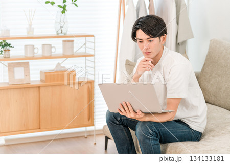 ソファーに座りパソコンを使う若いアジア人男性(フリーランス,クリエイター,プログラマー) ソファーに座りパソコンを使う若いアジア人男性(フリーランス,クリエイター,プログラマー) 134133181