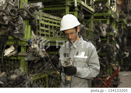 Technician worker working and checking in garage scrap yard car workshop warehouse. 134133205