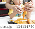 キッチンで親子で人参の皮を剥く母親と息子 134134750
