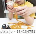 キッチンで親子で人参の皮を剥く母親と息子 134134751