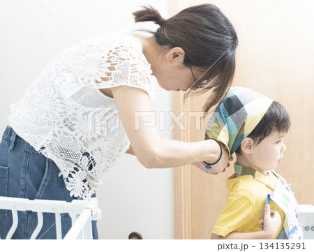 息子の三角巾とエプロンをつける母親 134135291