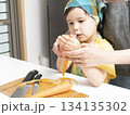 キッチンで親子で人参の皮を剥く母親と息子 134135302