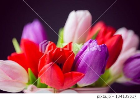 Flat design is showing multicolored tulip bouquet with light-colored container and green stems 134135617