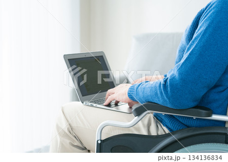 ノートパソコンを使う車椅子の男性 134136834