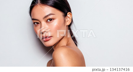 Model poses against a plain background showcasing natural beauty and simplicity in a fresh, clean look 134137416