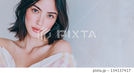 Woman with natural beauty poses softly in a light background, showcasing her elegance and charm in casual attire, perfect for a fashion setting 134137417