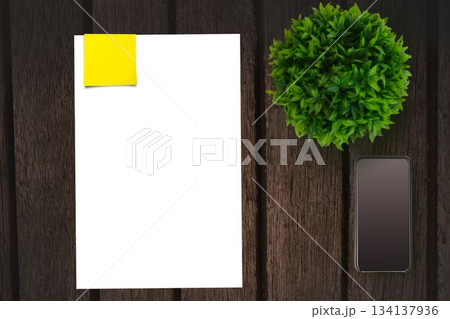 Table with a sheet of paper and a mobile phone Table with a sheet of paper and a mobile phone 134137936