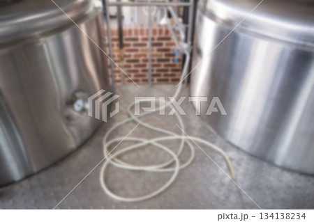 Defocused image of hose by storage tank at brewery factory Defocused image of hose by storage tank at brewery factory 134138234