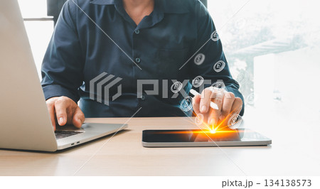 Man using laptop and digital tablet with glowing virtual currency icons, representing online payment, financial technology, digital transactions and modern money management solutions for businesses. Man using laptop and digital tablet with glowing virtual currency icons, representing online payment, financial technology, digital transactions and modern money management solutions for businesses. 134138573