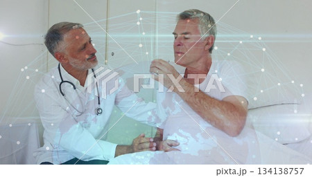 Consulting doctor placing hand on patient arm at hospital bed, with stethoscope and water glass Consulting doctor placing hand on patient arm at hospital bed, with stethoscope and water glass 134138757