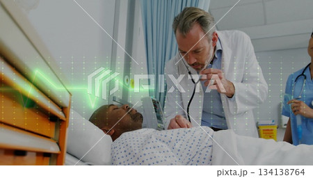 Leaning doctor listening to patient chest under patterned gown at hospital bed, with stethoscope Leaning doctor listening to patient chest under patterned gown at hospital bed, with stethoscope 134138764