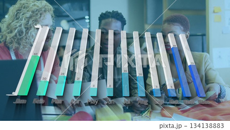 Reviewing three coworkers discussing materials around table in office, with bar chart overlay Reviewing three coworkers discussing materials around table in office, with bar chart overlay 134138883
